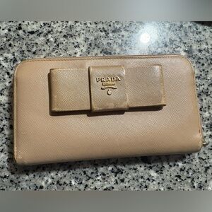 100% Authentic Prada Saffiano leather bow zip-around wallet in a beige